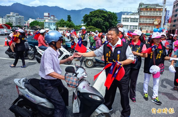 打算先挑戰國民黨地方黨部主委,再爭取花蓮縣長選舉的議長賴進坤(右),到市區發國旗。(記者花孟璟攝)