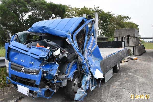 小貨車因撞擊力道猛烈車道嚴重扭曲變形。(記者黃淑莉攝)