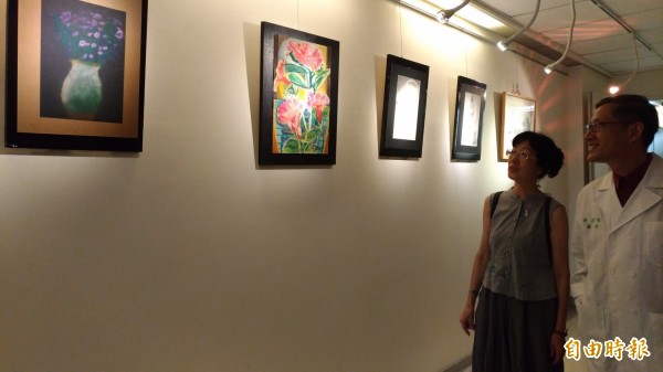 林淑紅為愛子畫展導覽,說明兒子的畫作主題幾乎都是日常生活。(記者廖淑玲攝)