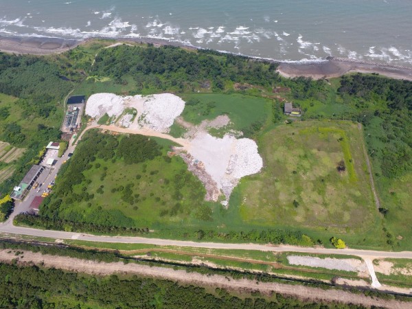 新竹縣新豐海岸遭環保團體批評是「最毒海岸線」,非法棄置的廢棄物就位在掩埋場外沿岸約2公里長。(新竹縣政府提供)