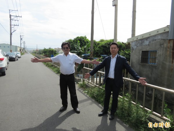 中市龍津高中靠近西濱的三港路道路未拓寬，每逢上下學便塞車，市議員陳世凱（右）與龍津里長張坤雄（左）要求市府徵地拓寬。（記者蘇金鳳攝）