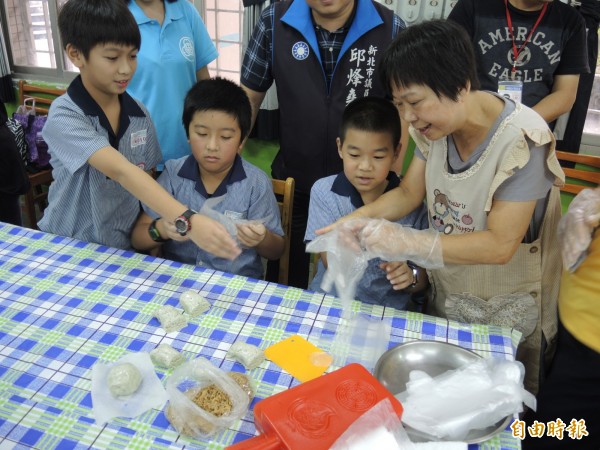 竹林中學老師協助在中和國小教小朋友唱客家山歌、製作和品嚐客家美食。（記者翁聿煌攝）