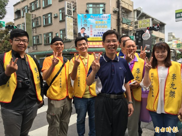 李允傑（中）掛看板，在志工團陪同下發表參選市長，要打造進步發展的嘉義等宣言。（記者王善嬿攝）