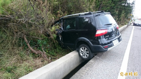 黑色休旅車因衝擊力過大，原地打轉後衝入草叢。（記者劉禹慶攝）