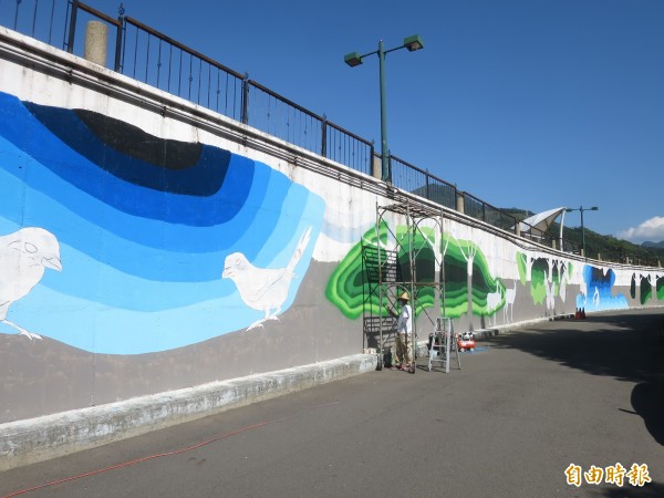 水里鄉公所在水里溪河堤牆面製作彩繪，盼美化水岸自行車道景觀。（記者劉濱銓攝）