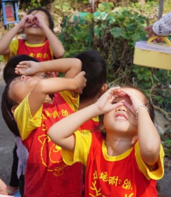 圳堵國小附設幼兒園小朋友圈起小手代替望遠鏡，望向天空觀察鳥仔。（圖由圳堵國小提供）