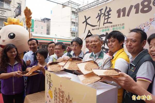 大雅區小麥麵食文化節於18日舉行，大雅區長林宜賢（左六）與地方民代一起將小麥倒入箱子裡，象徵豐收。（記者歐素美攝）