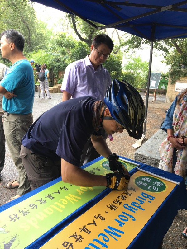 林昆海（中）簽名宣示踏訪全台濕地。（中華鳥會提供）