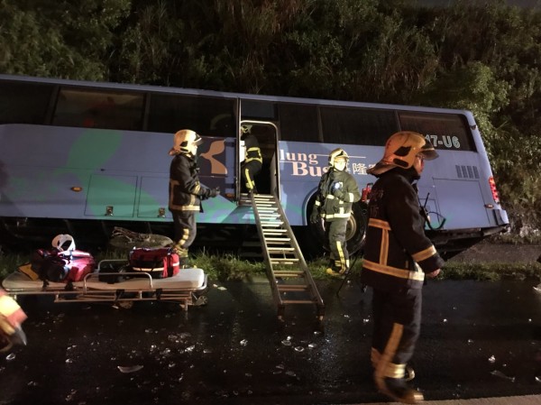 基隆客運今晚在國道三號北上10.3公里處，失控自撞路燈後翻車，消防員馳援救出駕駛與8名乘客。（記者林嘉東翻攝）