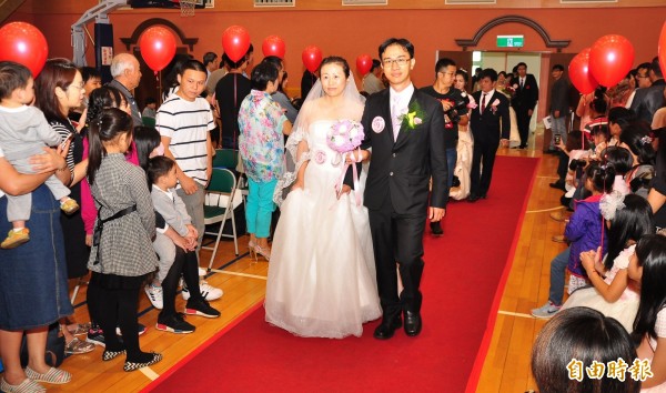 中鋼集團今天舉行台中場集團結婚，51對新人開心走紅地毯進場。（記者陳建志攝）