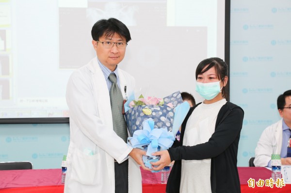 李婦(右)送花感謝童綜合醫院婦產部產科主任魏添勇。(記者張軒哲攝)