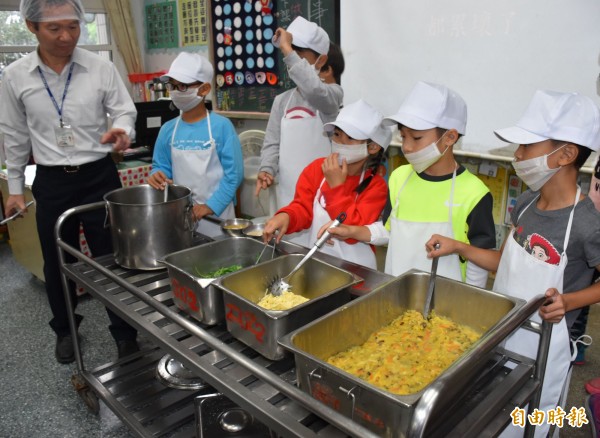 中壢青埔國小今天營養午餐有黃金蘿蔔糕、豆薯炒蛋、蒸青菜加醬汁、白菜海帶豆腐湯菜色，學童打菜覺得新鮮。（記者李容萍攝）