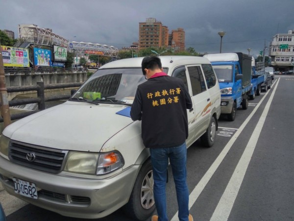 桃園分署、交通局合作執法，今天在蘆竹區錦溪街查扣、拖吊長期欠費的車輛。（桃園分署提供）