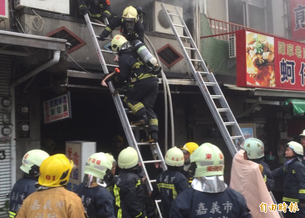 嘉義市北榮街一戶民宅昨天下午火,消防人員灌救滅火,並搜索火場尋找受困5歲男童,遺憾尋獲為時已晚,他已受烈火濃煙而無生命跡象,圖為消防抱往生男童離開火場。(記者陳璟民攝)