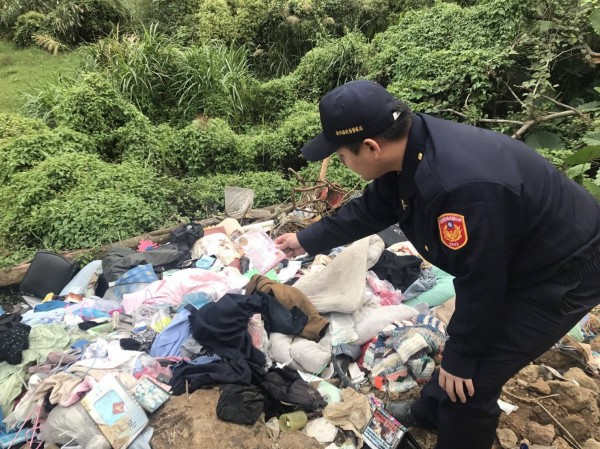 新竹縣北埔鄉外坪村山谷遭棄置大批廢棄物，警員在垃圾堆裡翻找線索。（圖由警方提供）