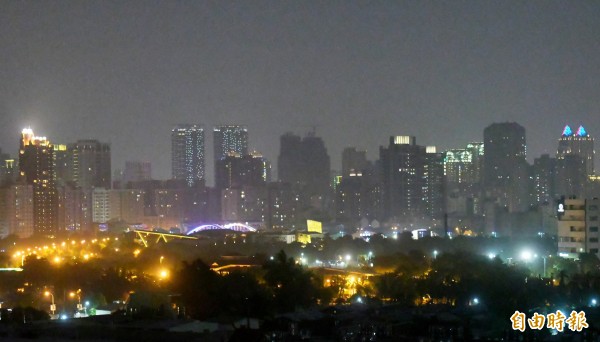 圖為晚間遠眺出現橘色警示的高雄左營區夜空。(記者黃志源攝)