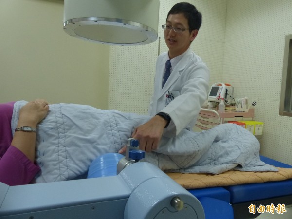 金門醫院泌尿科主任翁文慶(立者)說明體外震波碎石機採用電磁式原理產生震波。(記者吳正庭攝)
