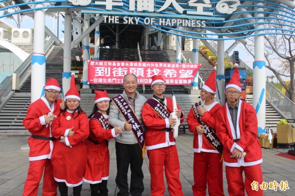 喜憨兒大器樂團與催生者林啟通，到國道清水服務區進行耶誕演出。（記者李忠憲攝）