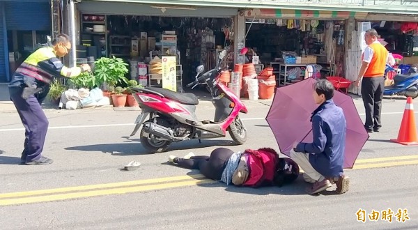 南投縣今發生1起交通事故，王姓汽車駕駛不但坦然以對，還幫倒地不起的張姓婦人撐傘遮陽的畫面，也被警方拍照存證。（記者謝介裕攝）