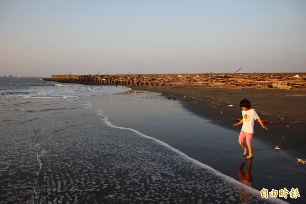 嘉義縣布袋鎮的小確幸海灘，海上夕陽景色相當美麗，也有民眾前往戲水。（記者林宜樟攝）