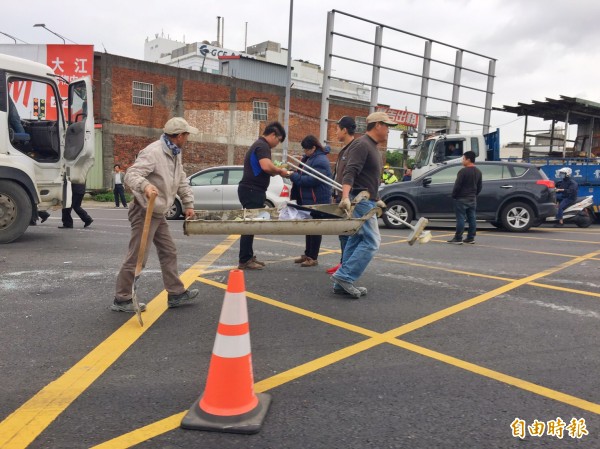 國道1號內壢交流道下水泥車翻覆，工作人員忙著善後清理路面。（記者李容萍攝）