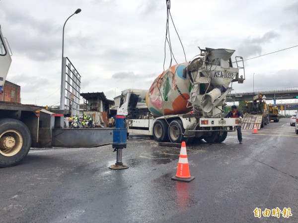 國道1號內壢交流道下水泥車翻覆，出動大型拖吊車來翻正。（記者李容萍攝）