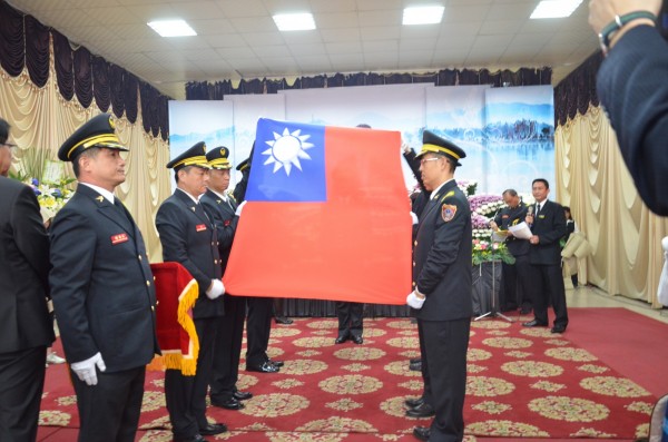 義消小隊長李俊宏救災殉職，屏東縣消防弟兄在他的靈柩覆蓋國旗。（記者李立法翻攝）