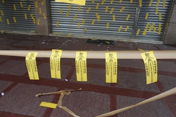 民進黨台中市黨部門口遭張貼上百張符咒。（記者李忠憲翻攝）