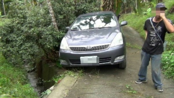 台中市童先生(右)與陳姓女友開車南下旅遊,2人誤闖石硦山區,倒車時車輪滑落邊坡空轉,差點翻落20公尺深的山溝。(中埔警分局提供)