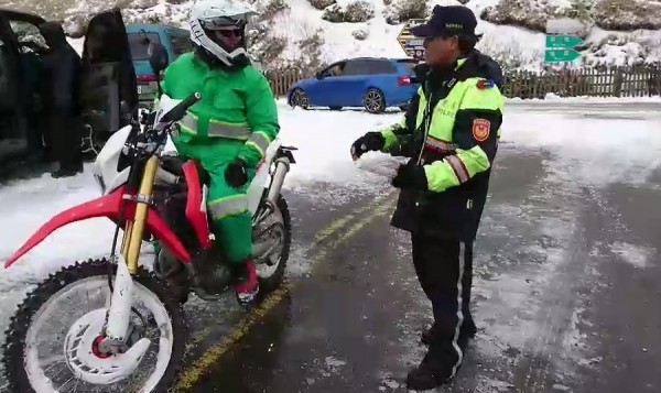 花蓮國安郵局外包投遞士游如鈁,奔波在皚皚白雪中的翠綠色身影,被一旁賞雪民眾及警方讚譽「史上最強郵差!」 (記者王峻祺翻攝)