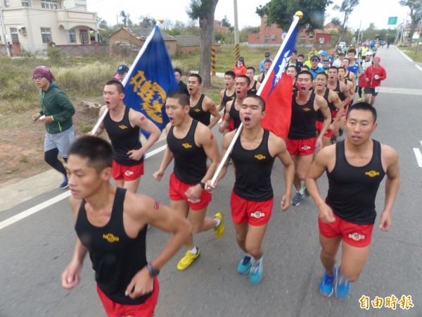 金防部海龍蛙兵拿著國旗、隊旗,唱歌答數,沿途為馬拉松選手提振士氣。(記者吳正庭攝)