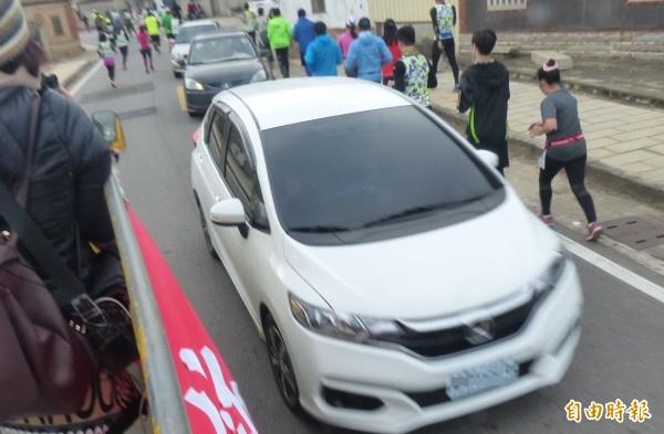 金門馬拉松沿路仍有不少人車爭道的驚險狀況。(記者吳正庭攝)