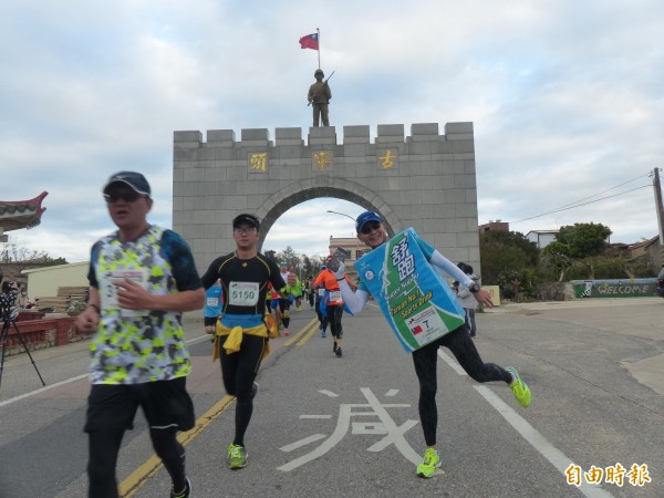 詹益榮(右一)穿著約三公斤的「舒跑」參加金門馬拉松。(記者吳正庭攝)