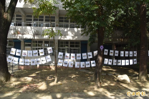 每位同學的攝影作品，以童軍繩串接綁在樹幹上展覽，成為校園另類風景。（記者蘇福男攝）