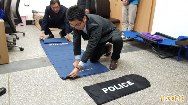 廠商示範自動充氣床墊使用，員警也試躺體驗。（記者彭健禮攝）