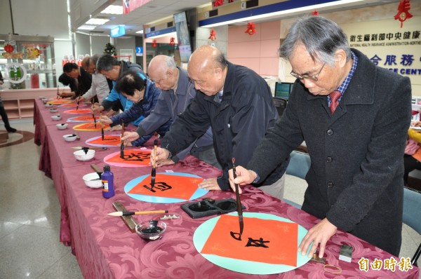 中央健保署北區業務組舉辦「金犬賜福迎新春，名家揮毫贈春聯」活動。（記者周敏鴻攝）