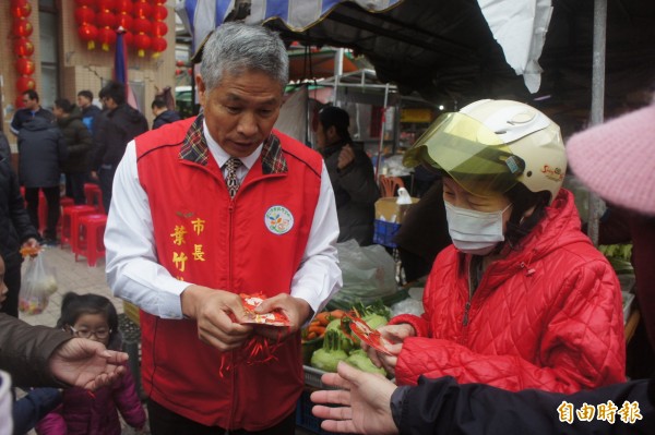 葉竹林分發一元復始紅包，吸引民眾踴躍索取。（記者劉禹慶攝）