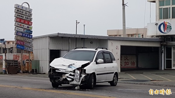 白色自小客車在加油站加完油，與重機對撞車頭毀損。（記者劉禹慶攝）