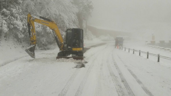 怪手剷除路面積雪。(記者江志雄翻攝)