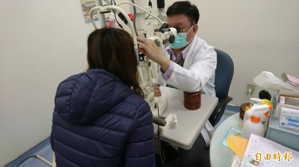 蔡姓女子在童綜合眼科看診檢查。(記者張軒哲攝)