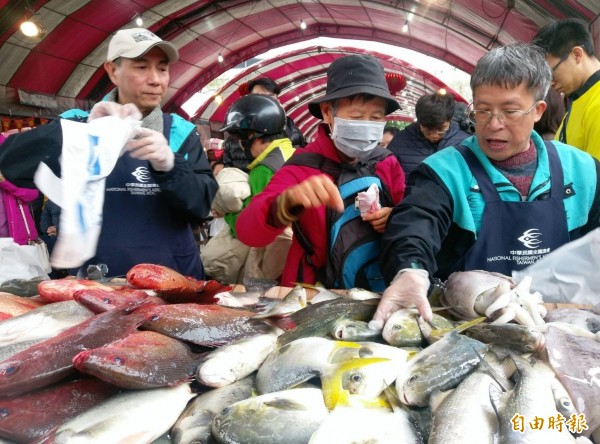 民眾排隊搶買百元鮮魚,買氣強強滾。(記者葉冠妤攝)