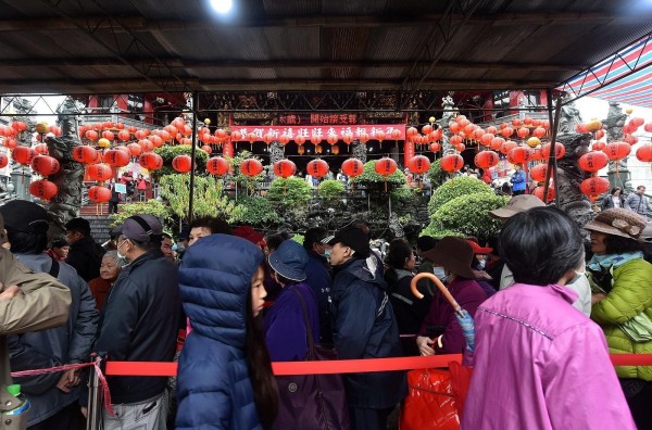 蘆洲湧蓮寺及三重義天宮鄰近菜市場，一早廟前即大排長龍，都是前來領取春聯、福袋的民眾。（圖由新北市政府民政局提供）