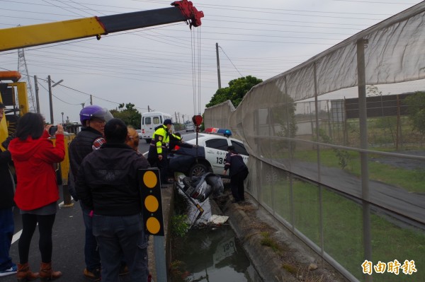 警方請來吊車吊起跌落測溝機車。（記者林國賢攝）