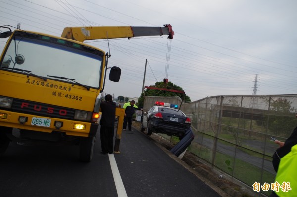 吊車將警車吊離果園。（記者林國賢攝）