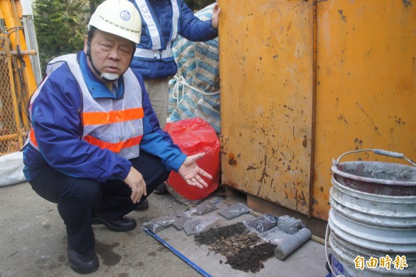 澎湖縣長陳光復指著地上玄武岩，因質地過於堅硬造成地下施工困難。（記者劉禹慶攝）