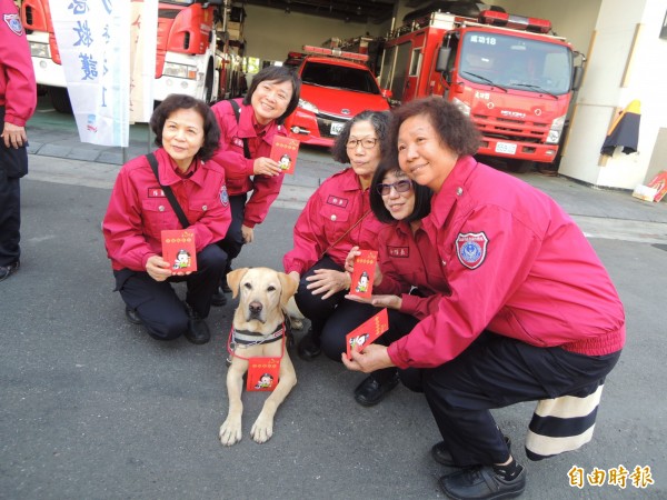 消防職員搶著和搜救犬拍照。（記者黃旭磊攝）