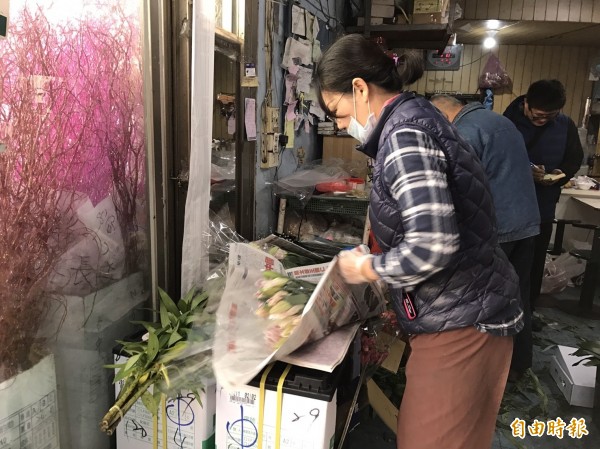 今天西洋情人節，又逢小年夜，花店業者忙打包消費者購買的花卉。（記者湯世名攝）