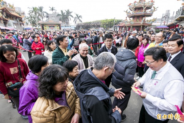 桃園市長鄭文燦勤走市轄宮廟發放春節福袋，民眾排隊爭拿市長福袋。（記者李容萍攝）