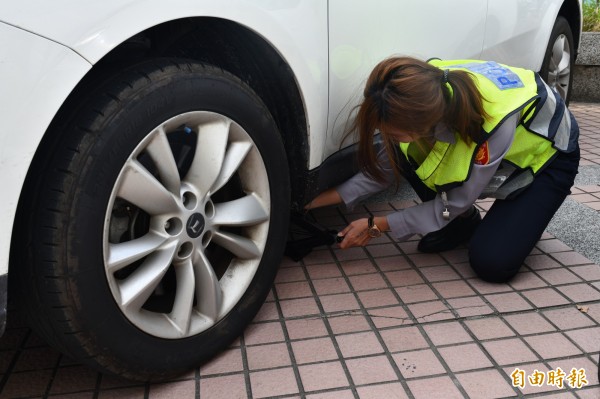 女警李怡茹示範換備胎。（記者蔡宗憲攝）