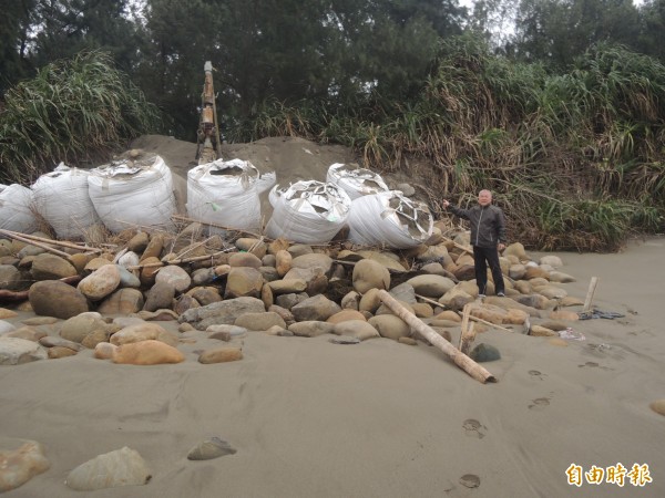 竹北市長何淦銘說，新月沙灣的沙子被海浪帶走了，位在岸邊的烏魚養殖場抽水設備也裸露，漁民自立救濟堆置沙包，保固抽水設備。（記者廖雪茹攝）